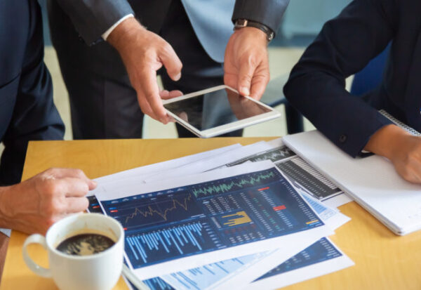 Unrecognizable business partners working with statistic charts